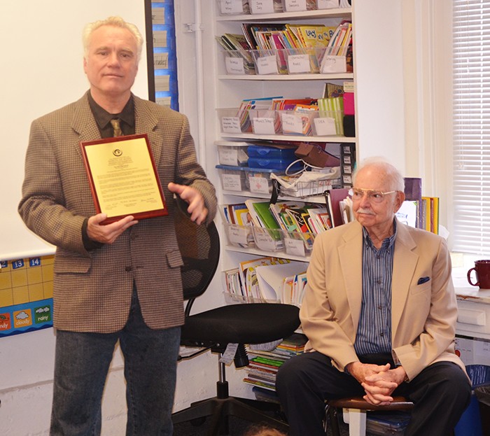 Kittredge School Principal Peter Lavaroni, at left, receives a plaque designating the school as a Habits of Mind-certified learning institution. Seated at right is Dr. Art Costa, co-founder of the Institute of Habits of Mind, who presented the award to Kittredge during an all-school assembly on Friday, May 15, 2015. (Photo: Kathleen Jay)