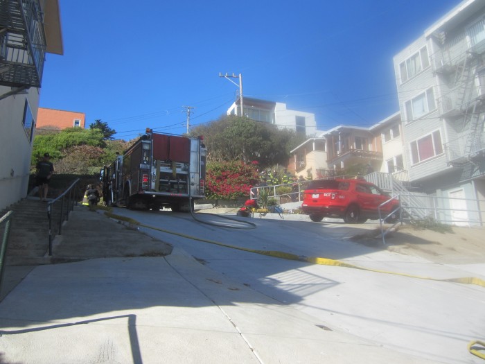 Firefighters set up below the steep hill where the car had crashed. Photo by Gabriel L.