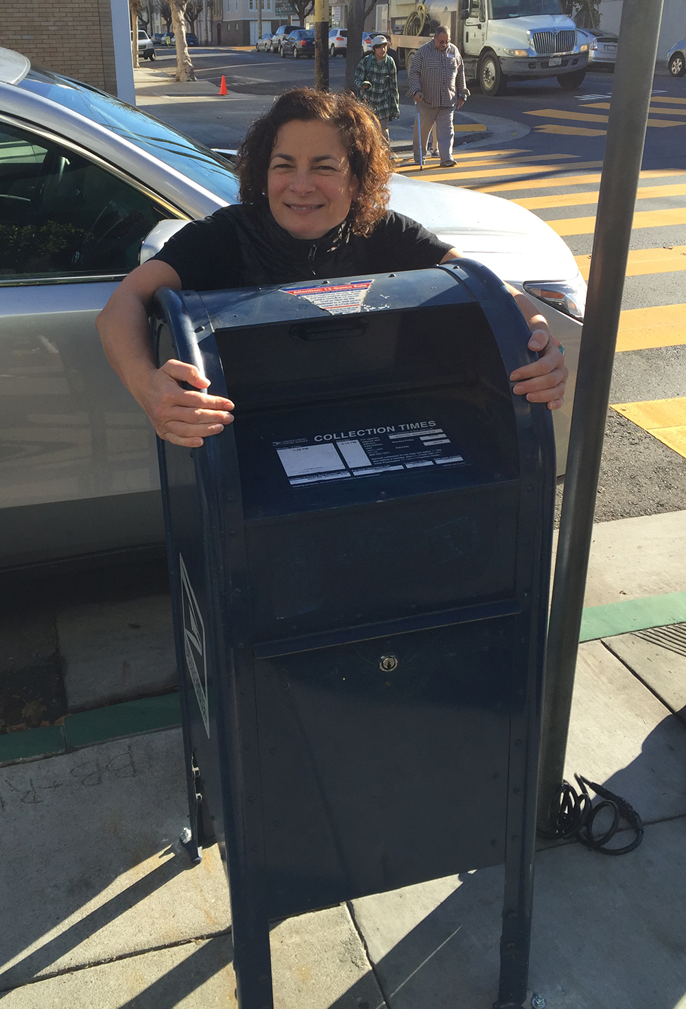 Angelina's Cafe owner Angie Rando gives the new USPS mailbox a welcoming hug