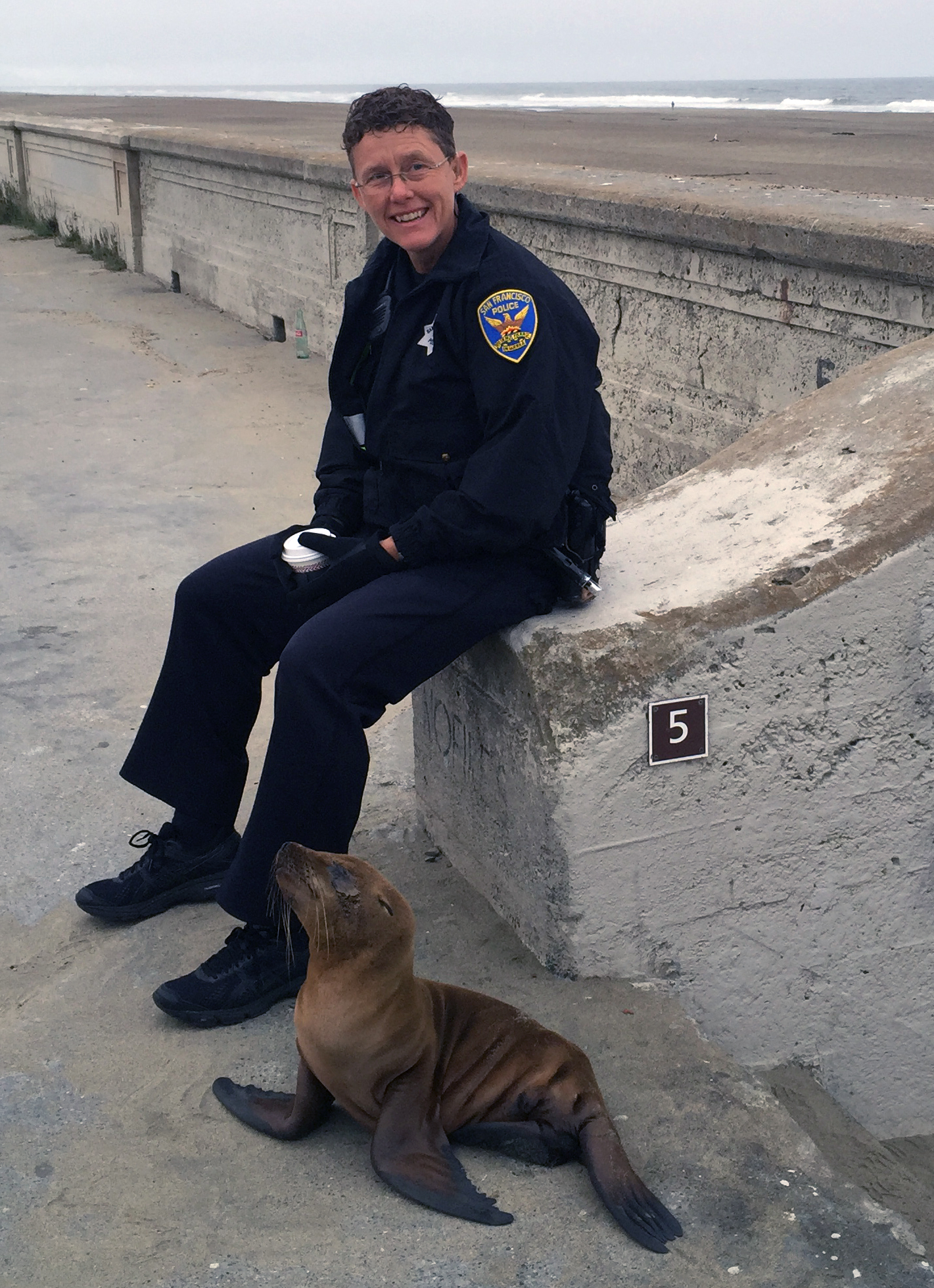 Officer Tracy Turner protects a stranded sea lion at Ocean Beach. Photo by Officer Annie Burrows