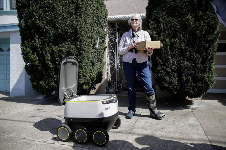 A starship delivery robot makes its first autonomous delivery of pastries to customer Julie O'Keefe (center), in San Francisco, California, on Tuesday, Sept. 20, 2016.  Photo: Gabrielle Lurie, Special To The Chronicle