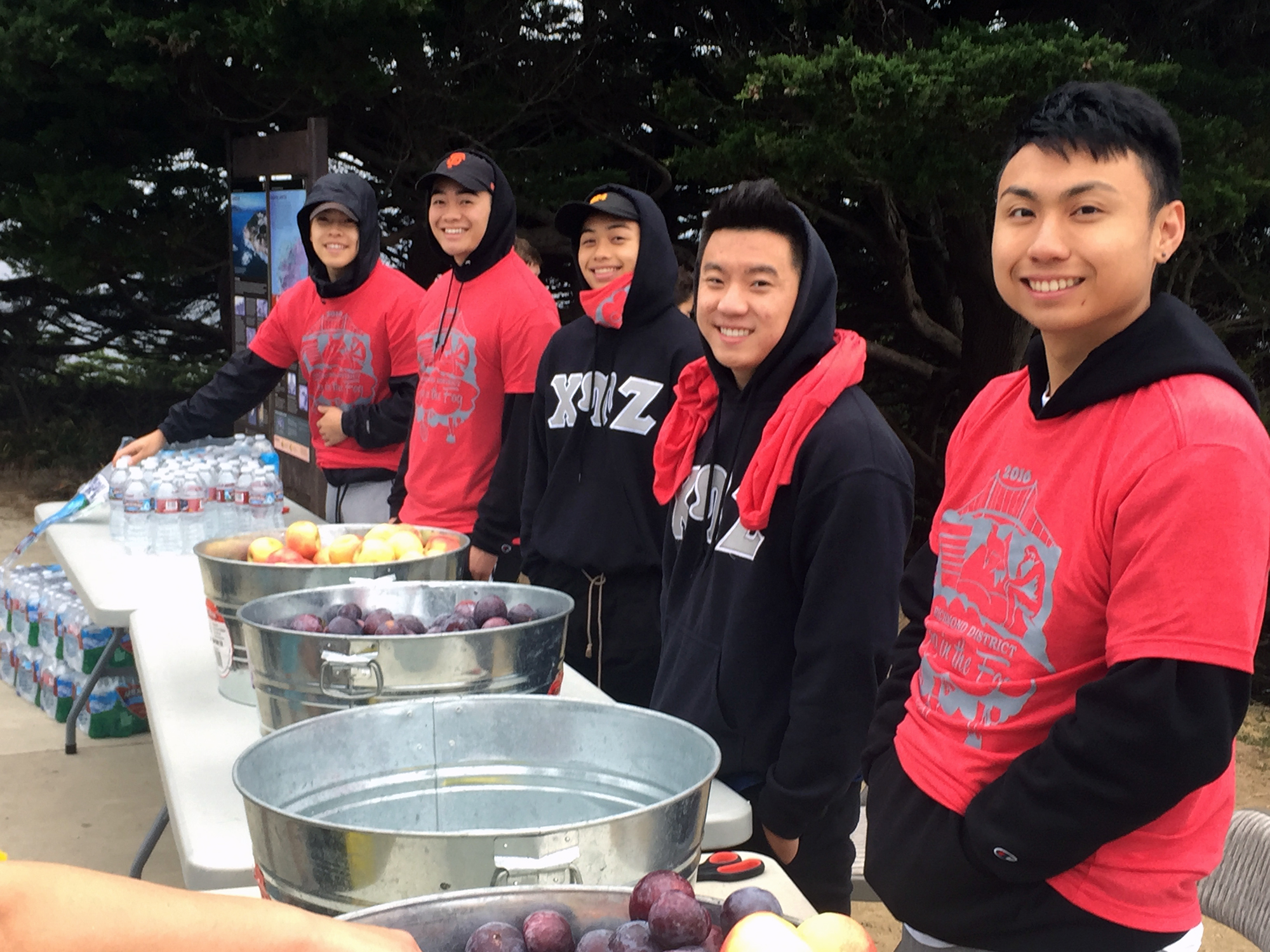 Volunteers from Chi Epsilon fraternity at USF help pass out fruit donated by Grocery Outlet